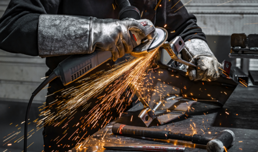 Trabajador utilizando una amoladora para lijar metal